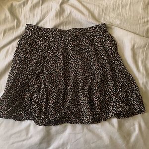 Black floral pattern skirt, mid length.